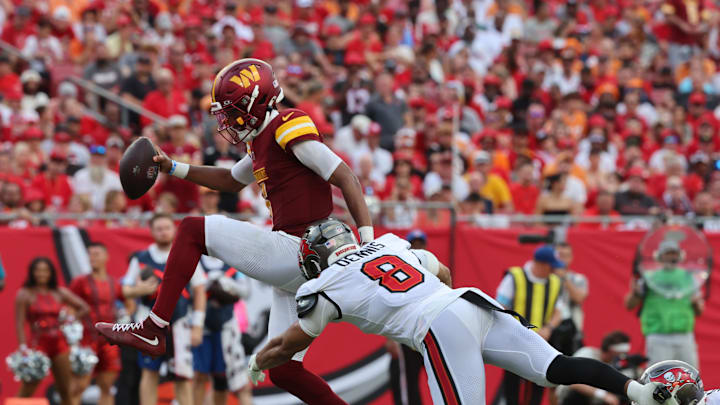 Sep 8, 2024; Tampa, Florida, USA;  Washington Commanders quarterback Jayden Daniels (5) runs past Tampa Bay Buccaneers linebacker SirVocea Dennis (8)  for a touchdown during the second half at Raymond James Stadium. Mandatory Credit: Kim Klement Neitzel-Imagn Images