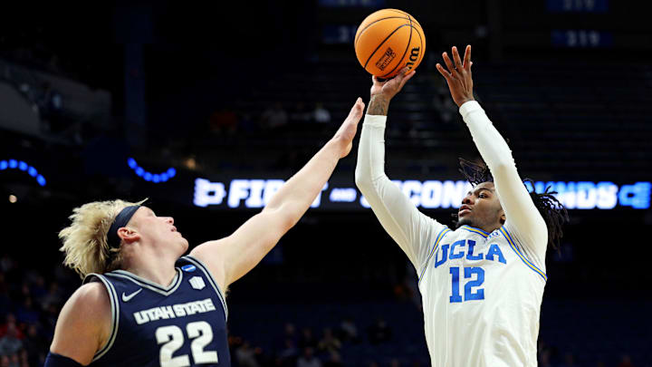 Mar 20, 2025; Lexington, KY, USA;  UCLA Bruins guard Sebastian Mack (12) shoots the ball against Utah State Aggies forward Karson Templin (22) during the second half in the first round of the NCAA Tournament at Rupp Arena. Mandatory Credit: Jordan Prather-Imagn Images
