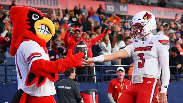 Oct 17, 2026; Syracuse, New York, USA; Louisville Cardinals quarterback Lincoln Kienholz (3) celebrates his touchdown run with the Louisville Cardinals mascot during the first half against the Syracuse Orange at the JMA Wireless Dome. Mandatory Credit: Rich Barnes-Imagn Images Oct 17, 2026; Syracuse, New York, USA; Louisville Cardinals quarterback Lincoln Kienholz (3) celebrates his touchdown run with the Louisville Cardinals mascot during the first half against the Syracuse Orange at the JMA Wireless Dome. Mandatory Credit: Rich Barnes-Imagn Images