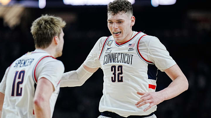 Connecticut guard Cam Spencer (12) and center Donovan Clingan (32) celebrate during the Final Four