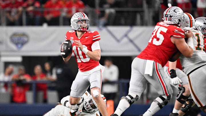 Dec 31, 2025; Arlington, TX, USA; Ohio State Buckeyes quarterback Julian Sayin (10) looks to throw in the fourth quarter while tackled by Miami Hurricanes defensive lineman Rueben Bain Jr. (4) during the 2025 Cotton Bowl and quarterfinal game of the College Football Playoff at AT&T Stadium. Mandatory Credit: Jerome Miron-Imagn Images Dec 31, 2025; Arlington, TX, USA; Ohio State Buckeyes quarterback Julian Sayin (10) looks to throw in the fourth quarter while tackled by Miami Hurricanes defensive lineman Rueben Bain Jr. (4) during the 2025 Cotton Bowl and quarterfinal game of the College Football Playoff at AT&T Stadium. Mandatory Credit: Jerome Miron-Imagn Images