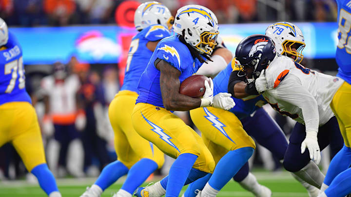Dec 19, 2024; Inglewood, California, USA; Los Angeles Chargers running back Gus Edwards (4) runs the ball against the Denver Broncos during the first half at SoFi Stadium. Mandatory Credit: Gary A. Vasquez-Imagn Images