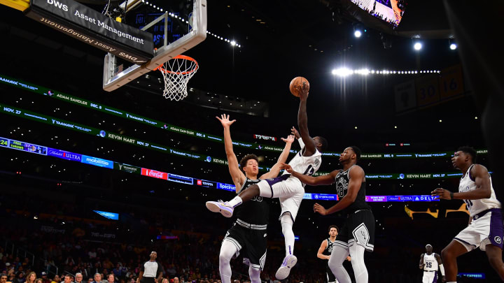 Nov 20, 2022; Los Angeles, California, USA; Los Angeles Lakers guard Kendrick Nunn (12) shoots against San Antonio Spurs center Charles Bassey (28) and forward Isaiah Roby (18) during the second half at Crypto.com Arena. Mandatory Credit: Gary A. Vasquez-USA TODAY Sports