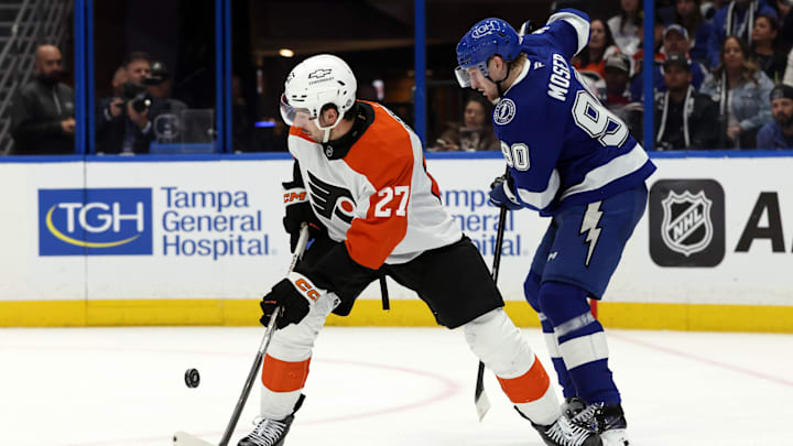 Mar 17, 2025; Tampa, Florida, USA;  Philadelphia Flyers left wing Noah Cates (27) skates with the puck as Tampa Bay Lightning defenseman J.J. Moser (90) defends during the second period at Amalie Arena. Mandatory Credit: Kim Klement Neitzel-Imagn Images