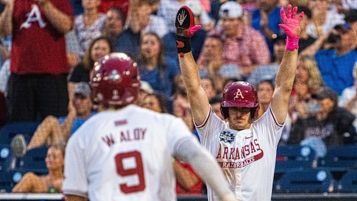 Jun 17, 2025; Omaha, Neb, USA; Arkansas Razorbacks third baseman Brent Iredale (10) celebrates as shortstop Wehiwa Aloy (9) scores on a two RBI double by right fielder Logan Maxwell (22) against the UCLA Bruins during the seventh inning at Charles Schwab Field. Mandatory Credit: Dylan Widger-Imagn Images