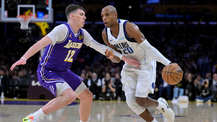 Feb 12, 2026; Los Angeles, California, USA;  Los Angeles Lakers forward Jake LaRavia (12) defends Dallas Mavericks forward Khris Middleton (20) in the second half at Crypto.com Arena. Mandatory Credit: Jayne Kamin-Oncea-Imagn Images