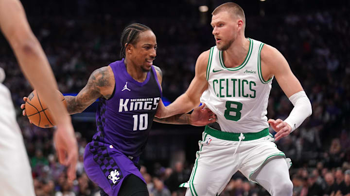 Mar 24, 2025; Sacramento, California, USA; Sacramento Kings guard DeMar DeRozan (10) dribbles the ball next to Boston Celtics forward Kristaps Porzingis (8) in the third quarter at the Golden 1 Center. Mandatory Credit: Cary Edmondson-Imagn Images