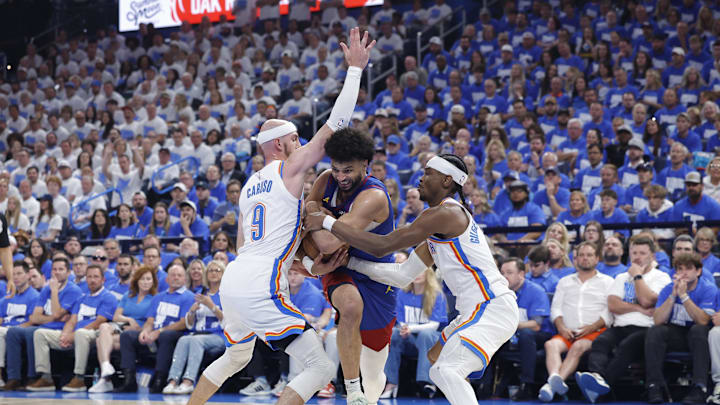 May 13, 2025; Oklahoma City, Oklahoma, USA; Denver Nuggets guard Jamal Murray (27) drives between Oklahoma City Thunder guard Alex Caruso (9) and guard Shai Gilgeous-Alexander (2) during the second quarter of game five of the second round for the 2025 NBA Playoffs at Paycom Center. Mandatory Credit: Alonzo Adams-Imagn Images May 13, 2025; Oklahoma City, Oklahoma, USA; Denver Nuggets guard Jamal Murray (27) drives between Oklahoma City Thunder guard Alex Caruso (9) and guard Shai Gilgeous-Alexander (2) during the second quarter of game five of the second round for the 2025 NBA Playoffs at Paycom Center. Mandatory Credit: Alonzo Adams-Imagn Images