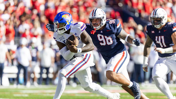 Nov 8, 2025; Tucson, Arizona, USA; Kansas Jayhawks quarterback Jalon Daniels (6) against Arizona Wildcats defensive lineman Tiaoalii Savea (98) at Arizona Stadium. Mandatory Credit: Mark J. Rebilas-Imagn Images Nov 8, 2025; Tucson, Arizona, USA; Kansas Jayhawks quarterback Jalon Daniels (6) against Arizona Wildcats defensive lineman Tiaoalii Savea (98) at Arizona Stadium. Mandatory Credit: Mark J. Rebilas-Imagn Images