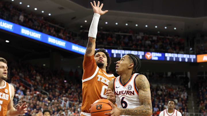 Jan 28, 2026; Auburn, Alabama, USA;  TTexas Longhorns guard Jordan Pope (0) grabs the arm and fouls Auburn Tigers guard Elyjah Freeman (6) during the second half at Neville Arena. Mandatory Credit: John Reed-Imagn Images