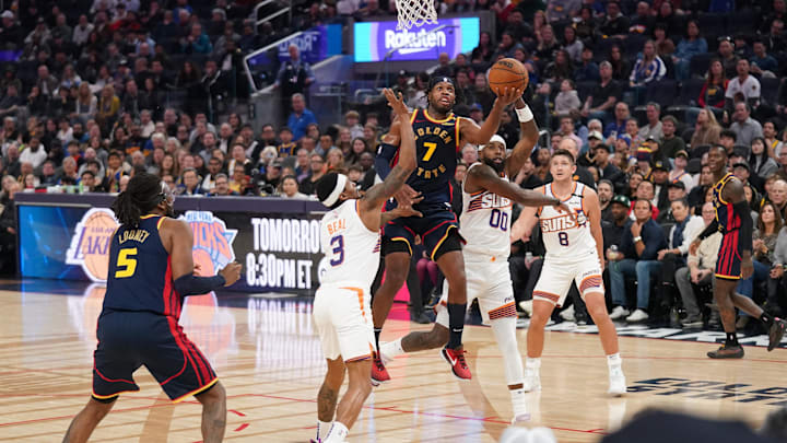 Jan 31, 2025; San Francisco, California, USA; Golden State Warriors guard Buddy Hield (7) makes a layup over Phoenix Suns guard Bradley Beal (3) in the second quarter at the Chase Center. Mandatory Credit: Cary Edmondson-Imagn Images