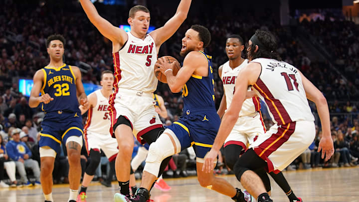 Dec 28, 2023; San Francisco, California, USA; Golden State Warriors guard Stephen Curry (30) drives on Nikola Jovic and Jaime Jaquez - Cary Edmondson-USA TODAY Sports 