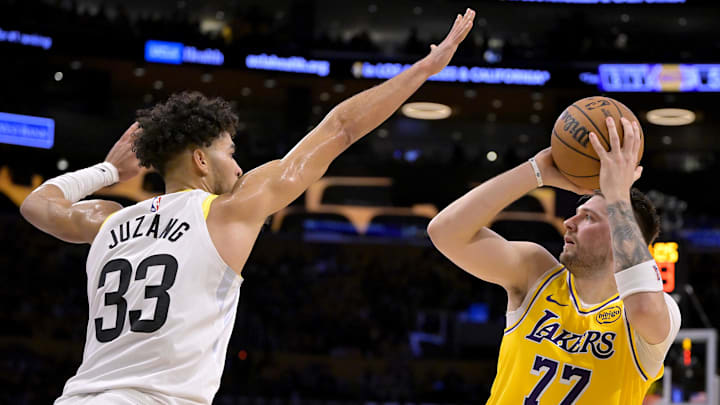 Feb 10, 2025; Los Angeles, California, USA; Los Angeles Lakers guard Luka Doncic (77) is defended by Utah Jazz guard Johnny Juzang (33) in the first half at Crypto.com Arena. Mandatory Credit: Jayne Kamin-Oncea-Imagn Images
