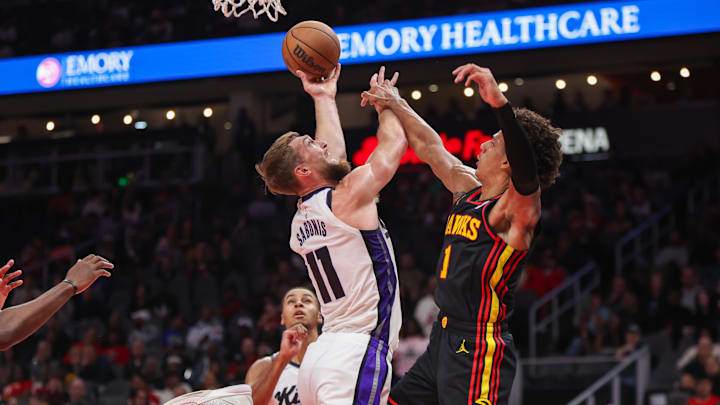 Nov 1, 2024; Atlanta, Georgia, USA; Sacramento Kings forward Domantas Sabonis (11) shoots past Atlanta Hawks forward Jalen Johnson (1) in the second quarter at State Farm Arena. Mandatory Credit: Brett Davis-Imagn Images