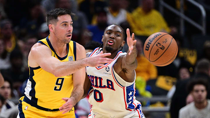 Oct 27, 2024; Indianapolis, Indiana, USA; Indiana Pacers guard T.J. McConnell (9) passes the ball around Philadelphia 76ers guard Tyrese Maxey (0) during the second half at Gainbridge Fieldhouse. Mandatory Credit: Marc Lebryk-Imagn Images