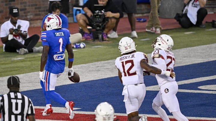 Sep 28, 2024; Dallas, Texas, USA; Southern Methodist Mustangs running back Brashard Smith (1) scores a touchdown past Florida State Seminoles defensive back Conrad Hussey (12) and defensive back Fentrell Cypress II (23) during the first quarter at Gerald J. Ford Stadium. Mandatory Credit: Jerome Miron-Imagn Images