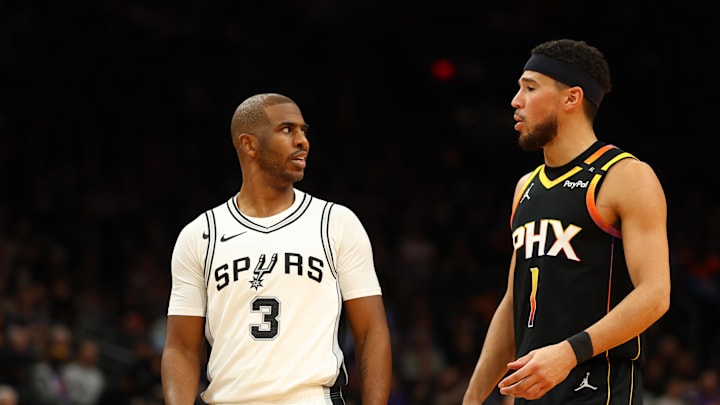 San Antonio Spurs guard Chris Paul talks to Phoenix Suns guard Devin Booker.
