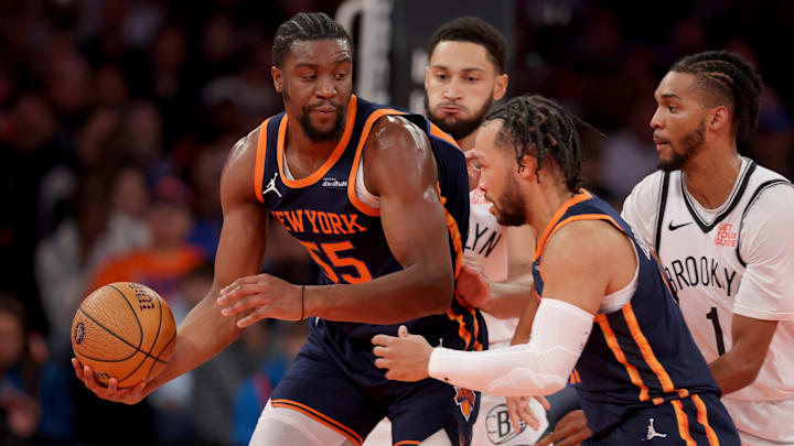 Nov 15, 2024; New York, New York, USA; New York Knicks center Ariel Hukporti (55) hands the ball off to guard Jalen Brunson (11) while guarded by Brooklyn Nets guard Ben Simmons (10) and forward Ziaire Williams (1) during the second quarter at Madison Square Garden. Mandatory Credit: Brad Penner-Imagn Images