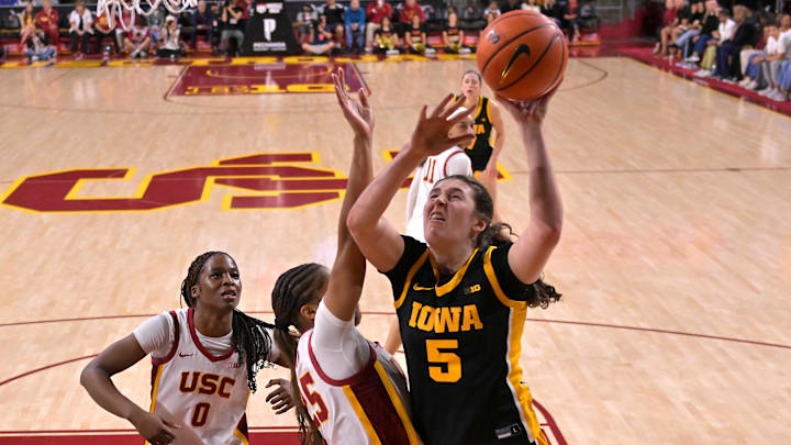 Jan 29, 2026; Los Angeles, California, USA; Iowa Hawkeyes guard Ava Heiden (5) is defended by USC Trojans forward Vivian Iwuchukwu (0) and guard Kara Dunn (25) as she drives for a basket in the second half at Galen Center. Mandatory Credit: Jayne Kamin-Oncea-Imagn Images