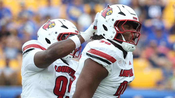 Sep 27, 2025; Pittsburgh, Pennsylvania, USA; Louisville Cardinals defensive lineman Rene Konga (90) celebrates his sack with defensive lineman Jerry Lawson (left) against the Pittsburgh Panthers during the fourth quarter at Acrisure Stadium. Mandatory Credit: Charles LeClaire-Imagn Images Sep 27, 2025; Pittsburgh, Pennsylvania, USA; Louisville Cardinals defensive lineman Rene Konga (90) celebrates his sack with defensive lineman Jerry Lawson (left) against the Pittsburgh Panthers during the fourth quarter at Acrisure Stadium. Mandatory Credit: Charles LeClaire-Imagn Images