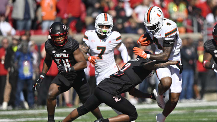 Oct 19, 2024; Louisville, Kentucky, USA;   Miami Hurricanes running back Mark Fletcher Jr. (4) runs the ball against Louisville Cardinals defensive back Tamarion McDonald (12) during the first half at L&N Federal Credit Union Stadium. Miami defeated Louisville 52-45. 