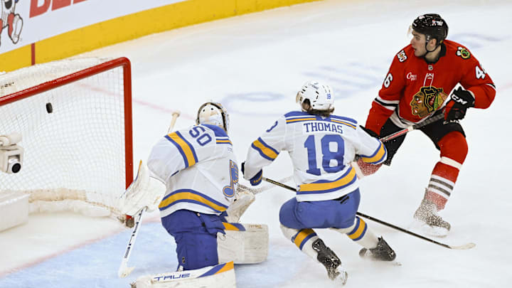 Jan 7, 2026; Chicago, Illinois, USA; Chicago Blackhawks defenseman Louis Crevier (46) scores a goal past St. Louis Blues goaltender Jordan Binnington (50) and center Robert Thomas (18) during the third period at the United Center. Mandatory Credit: Matt Marton-Imagn Images Jan 7, 2026; Chicago, Illinois, USA; Chicago Blackhawks defenseman Louis Crevier (46) scores a goal past St. Louis Blues goaltender Jordan Binnington (50) and center Robert Thomas (18) during the third period at the United Center. Mandatory Credit: Matt Marton-Imagn Images