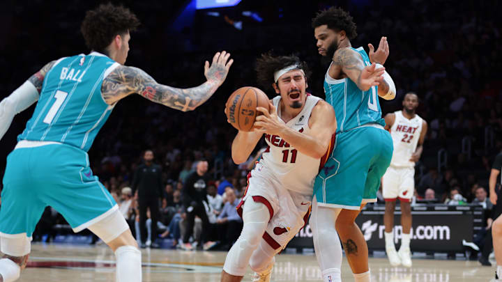 Oct 28, 2025; Miami, Florida, USA; Miami Heat guard Jaime Jaquez Jr. (11) drives to the basket against Charlotte Hornets forward Miles Bridges (0) and guard Lamelo Ball (1) during the third quarter at Kaseya Center. Mandatory Credit: Sam Navarro-Imagn Images