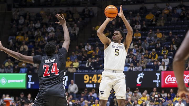 Jan 6, 2026; Morgantown, West Virginia, USA; West Virginia Mountaineers forward DJ Thomas (5) shoots over Cincinnati Bearcats forward Tyler McKinley (24) during the second half at Hope Coliseum. Mandatory Credit: Ben Queen-Imagn Images