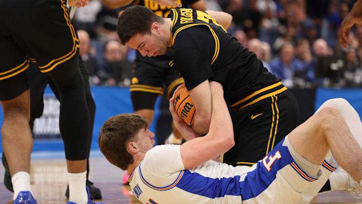Mar 22, 2026; Tampa, FL, USA; Florida Gators forward Alex Condon (21) and Iowa Hawkeyes forward Alvaro Folgueiras (7) force a jump ball in the first half during a second round game of the men's 2026 NCAA Tournament at Benchmark International Arena. Mandatory Credit: Nathan Ray Seebeck-Imagn Images