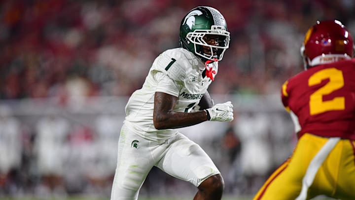 Sep 20, 2025; Los Angeles, California, USA; Michigan State Spartans wide receiver Omari Kelly (1) runs the ball against Southern California Trojans cornerback DJ Harvey (2) during the first half at the Los Angeles Memorial Coliseum. Mandatory Credit: Gary A. Vasquez-Imagn Images