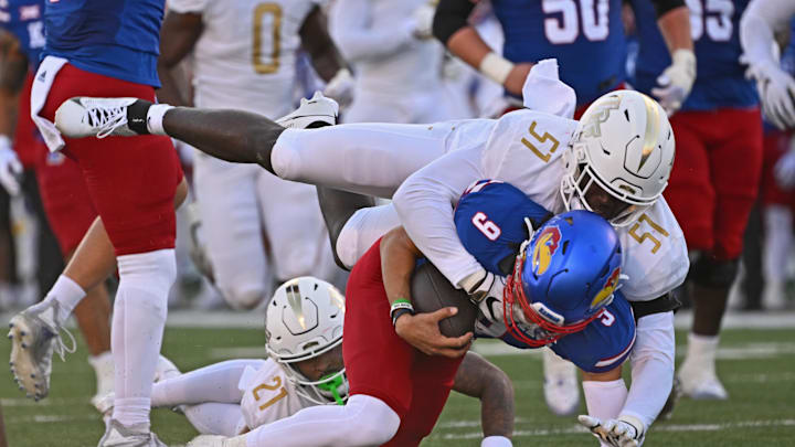 Oct 7, 2023; Lawrence, Kansas, USA; UCF Knights defensive end Malachi Lawrence (51) tackles Kansas Jayhawks quarterback Jason Bean (9) during the second half at David Booth Kansas Memorial Stadium. Mandatory Credit: Peter Aiken-Imagn Images Oct 7, 2023; Lawrence, Kansas, USA; UCF Knights defensive end Malachi Lawrence (51) tackles Kansas Jayhawks quarterback Jason Bean (9) during the second half at David Booth Kansas Memorial Stadium. Mandatory Credit: Peter Aiken-Imagn Images