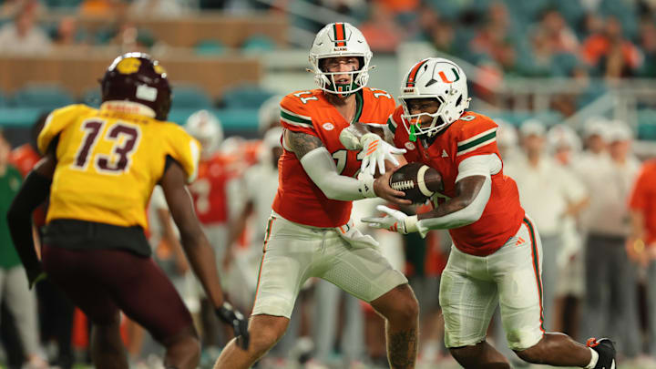 Sep 6, 2025; Miami Gardens, Florida, USA; Miami Hurricanes quarterback Carson Beck (11) handoff the football to running back CharMar Brown (6) against the Bethune-Cookman Wildcats during the second quarter at Hard Rock Stadium. Mandatory Credit: Sam Navarro-Imagn Images