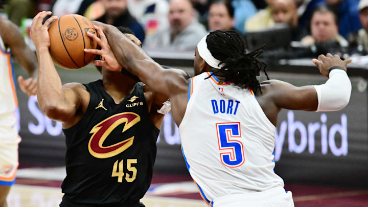Jan 19, 2026; Cleveland, Ohio, USA; Cleveland Cavaliers guard Donovan Mitchell (45) drives to the basket against Oklahoma City Thunder guard Luguentz Dort (5) during the second half at Rocket Arena.