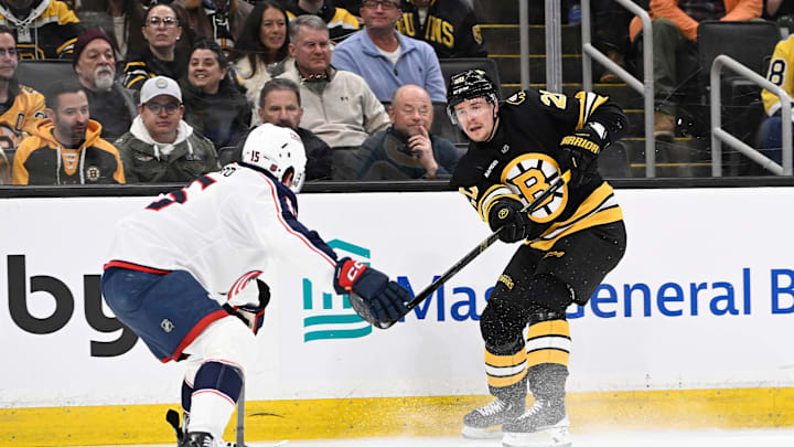 Feb 26, 2026; Boston, Massachusetts, USA; Boston Bruins defenseman Henri Jokiharju (20) shoots the puck by Columbus Blue Jackets defenseman Dante Fabbro (15) during the first period at TD Garden. Mandatory Credit: Eric Canha-Imagn Images