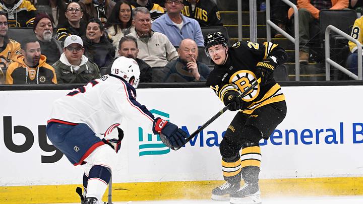Feb 26, 2026; Boston, Massachusetts, USA; Boston Bruins defenseman Henri Jokiharju (20) shoots the puck by Columbus Blue Jackets defenseman Dante Fabbro (15) during the first period at TD Garden. Mandatory Credit: Eric Canha-Imagn Images