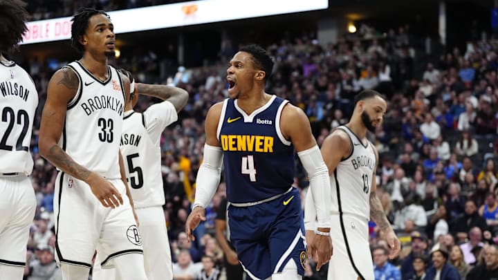 Jan 10, 2025; Denver, Colorado, USA; Denver Nuggets guard Russell Westbrook (4) reacts next to Brooklyn Nets center Nic Claxton (33) in the second quarter at Ball Arena. Mandatory Credit: Ron Chenoy-Imagn Images
