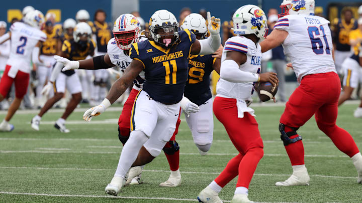 West Virginia University defensive lineman TJ Jackson pursues Kansas quarterback Jalon Daniels for a sack in the first quarter. 