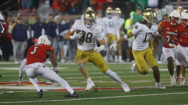 Notre Dame   s Mitchell Evens gets a first down against Louisville   s Quincy Riley at L & N Stadium.
Oct. 7, 2023