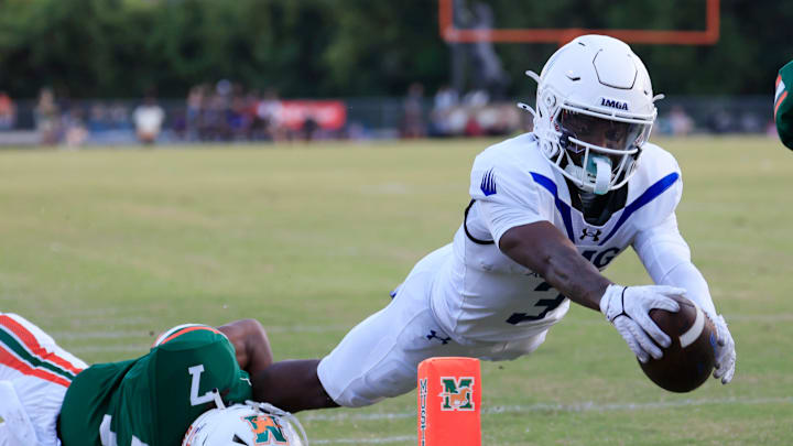 IMG Academy's Eric McFarland (3) scores a rushing touchdown against Mandarin's Tamajh Mitchell (7) during the first quarter of a high school football matchup at Mandarin High School, Friday, Sept. 19, 2025, in Jacksonville, Fla. The IMG Academy Ascenders defeated the Mandarin Mustangs 57-7.