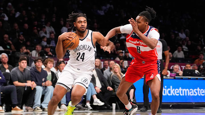 Oct 14, 2024; Brooklyn, New York, USA; Brooklyn Nets small guard Cam Thomas (24) drives the ball against Washington Wizards guard Bub Carrington (8) during the first half at Barclays Center. Mandatory Credit: Gregory Fisher-Imagn Images