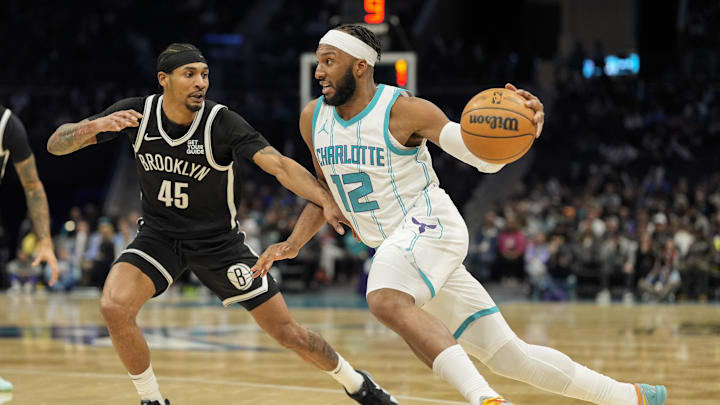 Jan 29, 2025; Charlotte, North Carolina, USA; Charlotte Hornets forward Josh Okogie (12) drives to the basket against Brooklyn Nets guard Keon Johnson (45) during the second half at Spectrum Center. Mandatory Credit: Jim Dedmon-Imagn Images