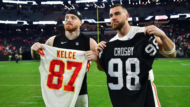 Jan 7, 2023; Paradise, Nevada, USA; Las Vegas Raiders defensive end Maxx Crosby (98) and Kansas City Chiefs tight end Travis Kelce (87) pose for photos after exchanging jerseys at Allegiant Stadium. Mandatory Credit: Gary A. Vasquez-USA TODAY Sports Jan 7, 2023; Paradise, Nevada, USA; Las Vegas Raiders defensive end Maxx Crosby (98) and Kansas City Chiefs tight end Travis Kelce (87) pose for photos after exchanging jerseys at Allegiant Stadium. Mandatory Credit: Gary A. Vasquez-USA TODAY Sports