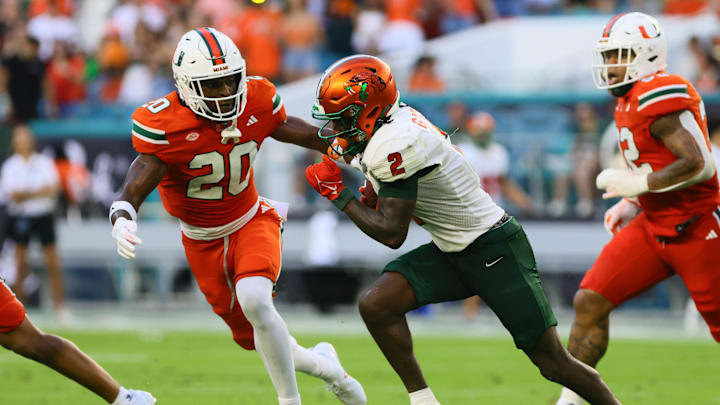 Sep 7, 2024; Miami Gardens, Florida, USA; Florida A&M Rattlers wide receiver Jamari Gassett (2) runs with the football against Miami Hurricanes defensive back Zaquan Patterson (20) during the second quarter at Hard Rock Stadium. Mandatory Credit: Sam Navarro-Imagn Images