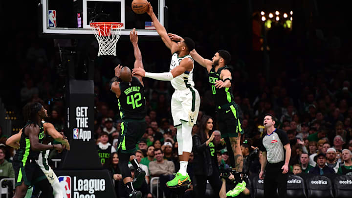 Dec 6, 2024; Boston, Massachusetts, USA;  Milwaukee Bucks forward Giannis Antetokounmpo (34) lays the ball in the basket between Boston Celtics center Al Horford (42) and forward Jayson Tatum (0) during the second half at TD Garden. Mandatory Credit: Bob DeChiara-Imagn Images
