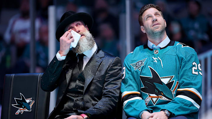 Nov 23, 2024; San Jose, California; San Jose Sharks former player Joe Thornton wipes away tears as he sits on the stage with former teammate Ryane Clowe at a ceremony honoring Thornton and retiring his number 19 jersey before a game between the San Jose Sharks and the Buffalo Sabres at SAP Center. Mandatory Credit: Ezra Shaw/Pool Photo via Imagn Images