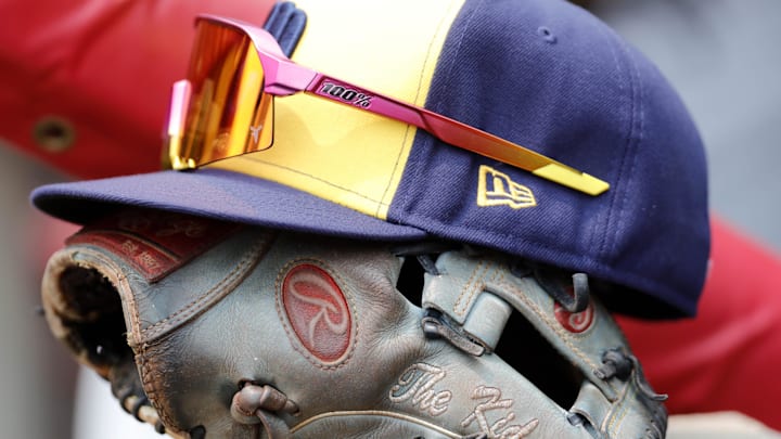 The hat and glove of Milwaukee Brewers shortstop Willy Adames (27) sits in the dugout during a game against the Cincinnati Reds at Great American Ball Park in 2023.