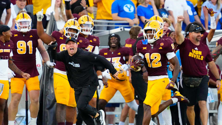 Arizona State head coach Kenny Dillingham runs with Arizona State defensive back Javan Robinson (12) as he returns an interception against BYU during the second half at Mountain America Stadium in Tempe on Nov. 23, 2024.