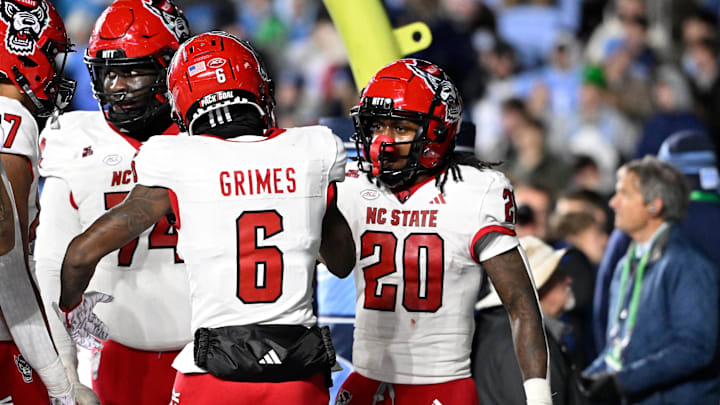 Nov 30, 2024; Chapel Hill, North Carolina, USA; North Carolina State Wolfpack running back Hollywood Smothers (20) reacts with wide receiver Wesley Grimes (6) after scoring a touchdown with 25 seconds to go in the fourth quarter at Kenan Memorial Stadium. Mandatory Credit: Bob Donnan-Imagn Images