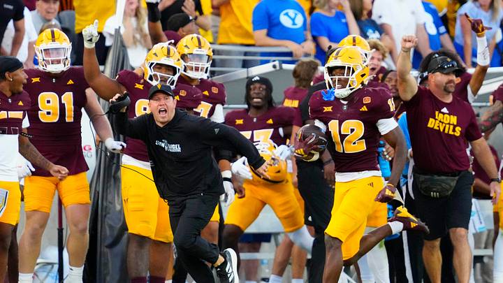 Arizona State head coach Kenny Dillingham runs with Arizona State defensive back Javan Robinson (12) as he returns an interception against BYU during the second half at Mountain America Stadium in Tempe on Nov. 23, 2024. Arizona State head coach Kenny Dillingham runs with Arizona State defensive back Javan Robinson (12) as he returns an interception against BYU during the second half at Mountain America Stadium in Tempe on Nov. 23, 2024.