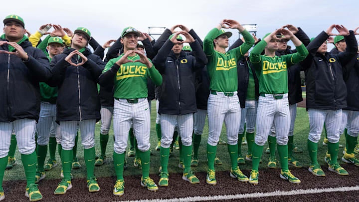 Oregon baseball players flash the “O” to fans after the Ducks beat the Toledo Rockets at PK Park in Eugene Saturday, Feb. 15, 2025.